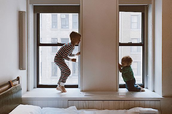 Zwei spielende Kinder two-kids-playing-beside-glass-windows-3273851.jpg